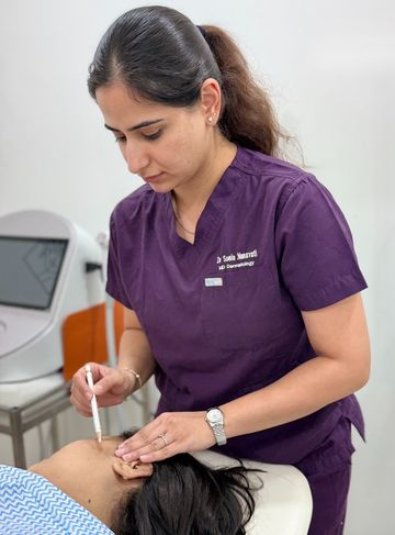 Dr. Sonia marking treatment guidelines on a patient's face