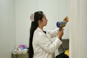 Clinic staff member preparing a handheld laser device for treatment